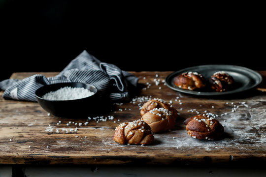 Close up of cardamom buns with sugar on wooden table