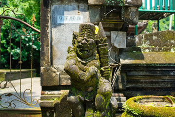 Stone sculpture covered by green moss in Ubud. Bali, Indonesia
