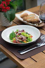 Healthy salad with fresh lattice and meat. Served on terrace of cafe. Prepared by chef