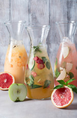Set of summer lemonades: lemon with black currant, orange, lime and cranberry, grapefruit and bloody orange with ice and fruits