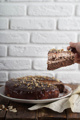 Raw vegan chocolate vanilla cheesecake with hazelnuts on wooden table, background