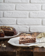Raw vegan chocolate vanilla cheesecake with hazelnuts on wooden table, background