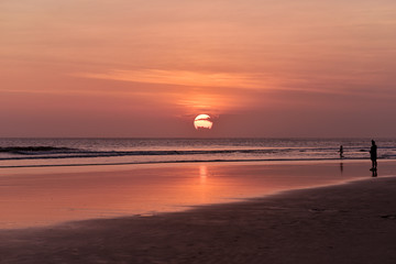 People walking on the Kuta Beach Bali Indonesia during sunset and low tide