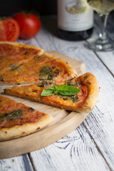 Rustic italian pizza with tomatoes cheese and basil leaves with glass of wine