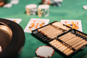 roulette and cigars and poker cards on table in casino