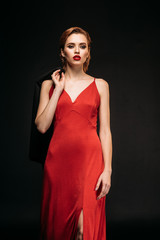 Fototapeta premium attractive girl in red dress and black jacket walking isolated on black