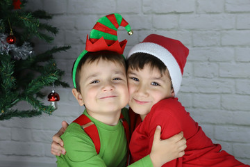 niños felices abrazados en navidad disfrazados de duende y Santa Claus 