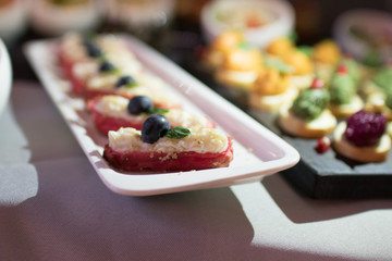 Beautifully decorated catering banquet table with different food snacks and appetizers on corporate christmas birthday party event or wedding celebration
