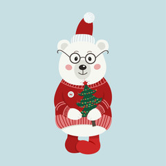 Isolated cute white bear is dresses in winter clothes and holds Christmas tree