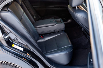 Clean after washing the rear passenger seats of matte black genuine leather inside the interior of an expensive sedan, preparation before selling the car.