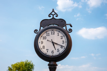 Fototapeta na wymiar town clock on blue sky background, close up