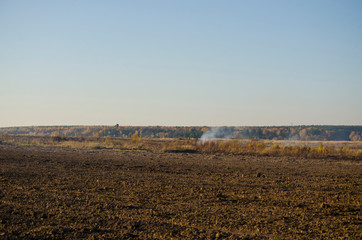 Burning dry grass in the fall, with smoke.