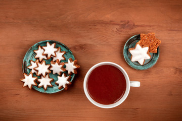 Christmas Zimtsterne, German cinnamon star cookies, shot from the top on a dark rustic wooden background with hot chocolate and a place for text