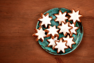 An overhead photo of Christmas Zimtsterne, traditional German almond, chocolate and cinnamon star cookies, shot from above with copy space