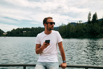 Modern guy using cellphone in the European city.