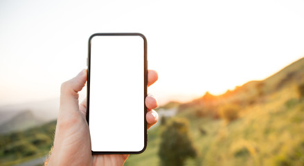 Hand of holding smartphone with white screen on nature background
