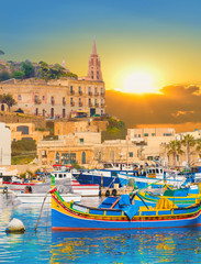 Marsaxlokk village harbor of Malta, illuminate by sunset light - obrazy, fototapety, plakaty