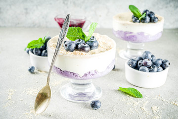 Sweet summer dessert, Blueberry no baked inverted cheesecake in glass, grey stone background copy space