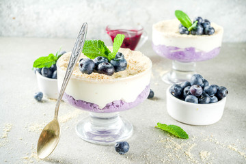 Sweet summer dessert, Blueberry no baked inverted cheesecake in glass, grey stone background copy space