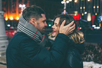 Real young couple walking together in night city, kissing and sm