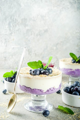 Sweet summer dessert, Blueberry no baked inverted cheesecake in glass, grey stone background copy space