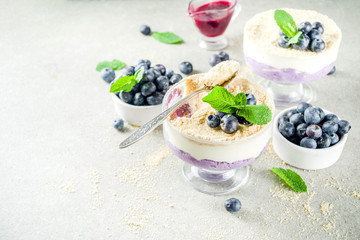 Sweet summer dessert, Blueberry no baked inverted cheesecake in glass, grey stone background copy space