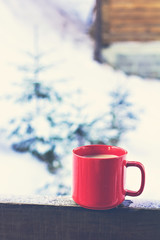 Cup with coffee, tea on the background of the winter landscape