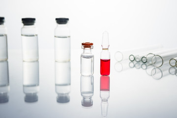 Group of vials with medication on blue methacrylate table.