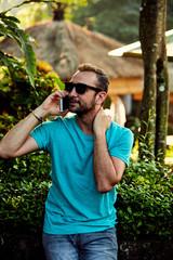 Modern man using cellphone outdoors.