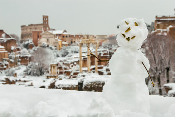 Snowman shows Roman Forum ancient monuments and Coliseum with snow
