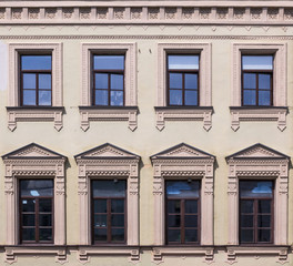 Fototapeta na wymiar Vintage architecture classical facade front view.The windows framed in Russian traditional style imitates the traditional national Russian style of wood carving