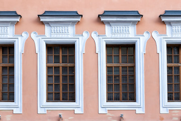 Fototapeta na wymiar Vintage architecture pink classical facade. Wall with framed windows front view