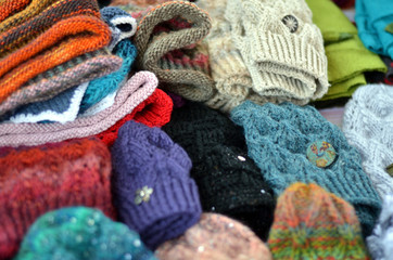 Viele bunte selbst gemachte Mützen und Handschuhe aus Wolle in einer Auslage