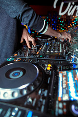 Obraz premium Dj mixes the track in the nightclub at party. In the background laser light show