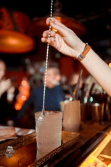 Fototapeta na wymiar Bartender is stirring cocktails on the bar counter