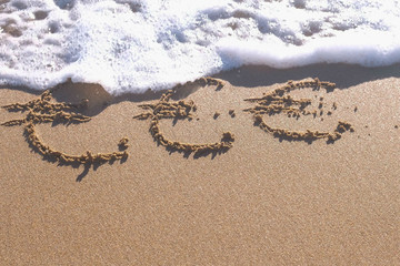 Euro signs written in the sea sand. Waves washed away the inscription.