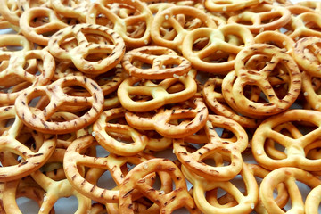 Salty crispy cracker mini pretzels on wooden background. Close up photography