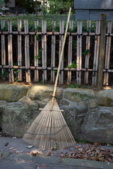  Bamboo rake leaning against a fence