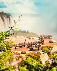 Fototapeta premium &nbsp;Close view of observation deck and bridges for tourists of the Cataratas water falls under blue sky, rainbow and a water mist at the Foz do Iguassu park - Brazil.