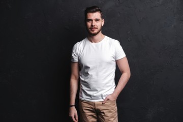 young fashion man posing for the camera on black background