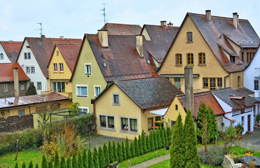 Fototapeta na wymiar German architecture. Nice houses with red tile roofs, chimneys, gardens. Germany. Bavaria. Rothenburg ob der Tauber.