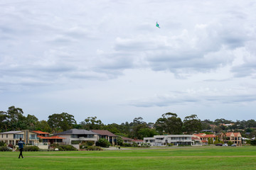 Afternoon cloudy landscape of a park and guy playing on the grass