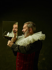 Official portrait of historical governor from the golden age with corrugated round collar with a glass of red wine. Studio shot against dark wall.