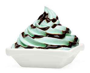 Mint whipped soft ice cream or frozen yogurt with chocolate sauce in dish or plate isolated on white background.