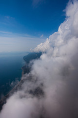 Obraz premium flight near the wall of clouds, free flight. Wall of clouds, blue sky and sea.