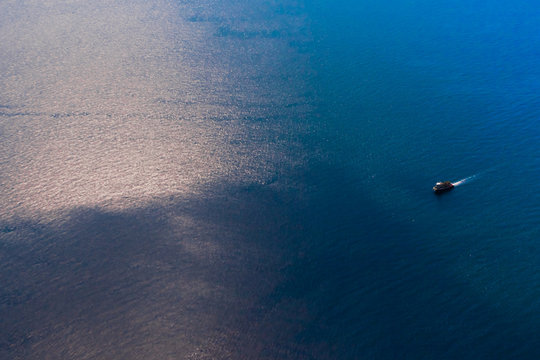 A small ship among the truncated blue sea, a view from a height.
