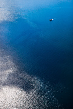 A small ship among the truncated blue sea, a view from a height.