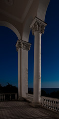 White columns against the sky and the sea, the ruins of the hotel.