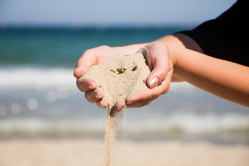 Hand holding sand. Hand with sand. Hand sand down gently on the beach 