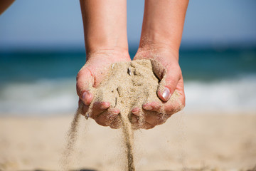 Hand holding sand. Hand with sand. Hand sand down gently on the beach  - Powered by Adobe